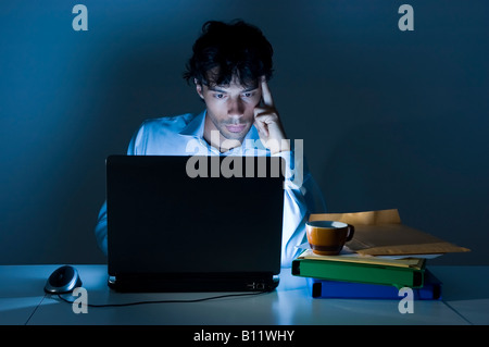 Junger Geschäftsmann Arbeiten konzentrieren sich auf seinem Laptop bis spät in die Nacht Stockfoto
