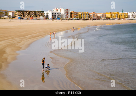 Ein paar Urlauber genießen einen Spaziergang am Strand von Barbate - Playa de Barbate - in der späten Nachmittagssonne. Playa de Barbate, Barbate, Cádiz, Andalucía, Spanien. Stockfoto