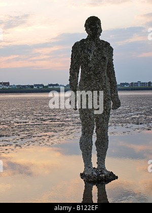 Antony Gormley geschnitzte Figur am Strand bei Crosby, Liverpool, Merseyside, England, Vereinigtes Königreich, Stockfoto