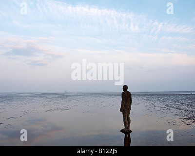 Antony Gormley geschnitzte Figur am Strand bei Crosby, Liverpool, Merseyside, England, Vereinigtes Königreich, Stockfoto