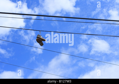 Paar Turnschuhe hängend von einem powerline Stockfoto