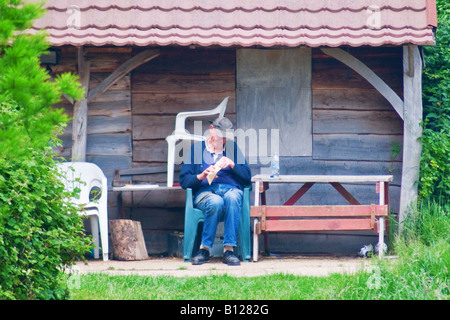 Eine ältere Person sitzt schlafend Dosierung Stockfoto