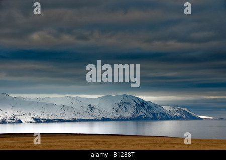 Sonnenuntergang über Skjalfandafloi Bay und Schnee bedeckt die Berge Viknafjoll, Husavik, Island Stockfoto