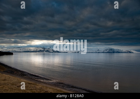 Sonnenuntergang über Skjalfandafloi Bay und Schnee bedeckt die Berge Viknafjoll, Husavik, Island Stockfoto