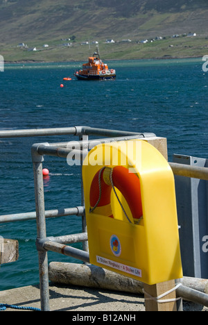 Rettungsring auf Hafenmauer mit Rettungsboot im Hintergrund, Achill Island County Mayo, Irland Stockfoto