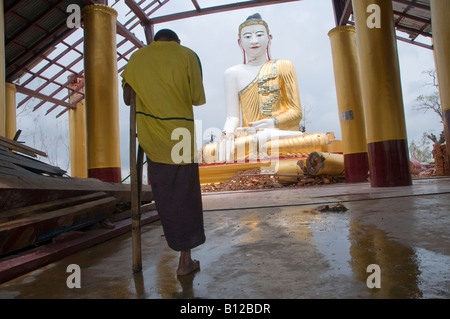 Buddhistischer Mönch betet in einem verfallenen buddhistischen Tempel verursacht durch den Zyklon Nargis in Zoung Dorf, Stadtrand von Yangon. Myanmar Stockfoto