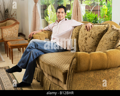 Junger Mann auf sofa Stockfoto