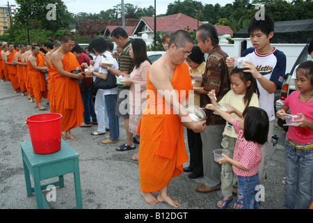 Buddhistische Mönche empfangen Almosen von Anhängern Stockfoto