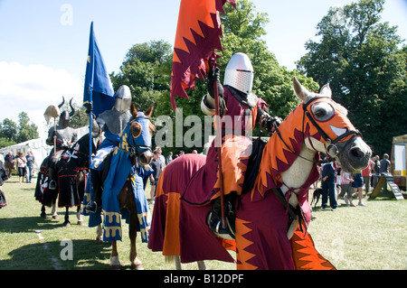 Ritter zu Pferd, mit Rüstung, mit Farben (Fahnen) während einer mittelalterlichen Messe Reenactment Stockfoto