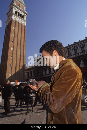 touristischen Fütterung Taube auf seiner Hand in Piazza San Marco Venice Italien Stockfoto