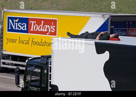 LKW-Fahrer Mittagessen Zeit schlafen oben auf seinem LKW in einer Layby auf die A120 in der Nähe von Stansted, Essex, England. Stockfoto