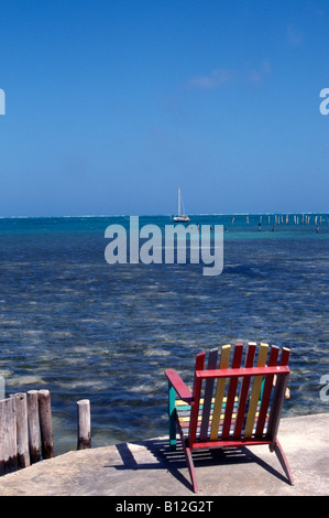 Wooden Liegestuhl mit Blick auf das blaue karibische Meer auf Caye Caulker, Belize, Central America Stockfoto