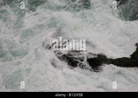 Wellen, die rings um den Felsen am Strand von Kovalam, Kerala, Indien Stockfoto