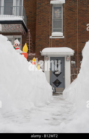 Ein Pfad zu einem Duplex-Haustür aus dem Schnee gebunden Montreal Vorort Straße nach einem schweren Schneesturm. Stockfoto