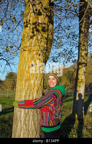 Frau umarmt einen Baum in der Natur. Spanien Europa Stockfoto