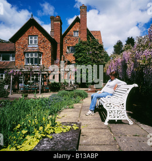 Frau in einem Garten Marle Ort Brenchley Nr Tonbridge Kent England UK entspannen. Stockfoto