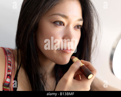 Junge asiatische Frauen Auftragen von Lippenstift. Stockfoto