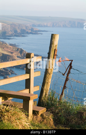 Hoher Blick auf die dunstige Küste an einem sonnigen Tag von einem Holzstile auf dem Küstenweg zwischen Mothecombe und Stoke, South Hams, Devon. GROSSBRITANNIEN Stockfoto