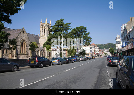 Llandudno Conwy North Wales UK kann Suche entlang der geschäftigen Main Mostyn Einkaufsstraße mit der Holy Trinity Church Stockfoto