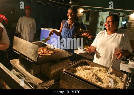 eine lokale Chef kochen bis ein Fisch braten auf dem Fischmarkt Oistins in Bridgetown, Barbados Stockfoto