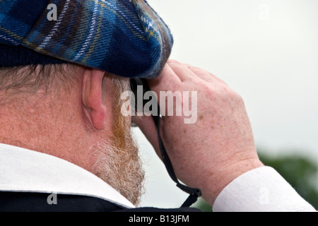 Nahaufnahme eines Gentleman, der Blick durch ein Fernglas am Perth Racecourse in Perthshire, Großbritannien Stockfoto