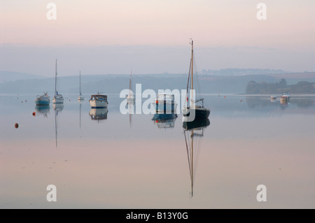 Yachten und Fischerboote fangen das erste Licht der Morgendämmerung an der Mündung der nebligen Kingsbridge Devon UK Stockfoto