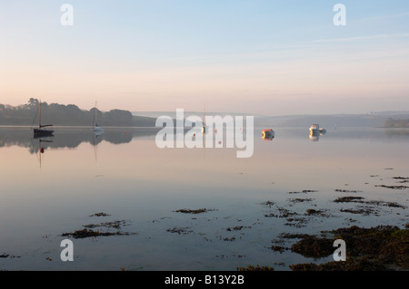 Yachten und Fischerboote fangen das erste Licht der Morgendämmerung an der Mündung der nebligen Kingsbridge Devon UK Stockfoto