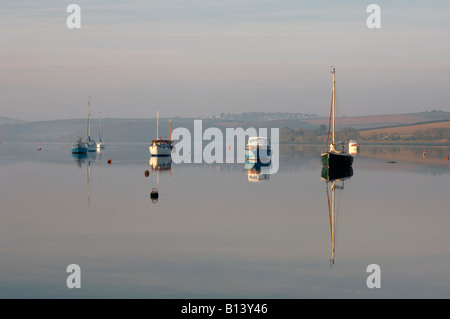 Yachten und Fischerboote fangen das erste Licht der Morgendämmerung an der Mündung der nebligen Kingsbridge Devon UK Stockfoto