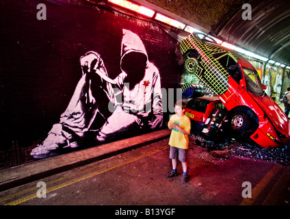 Sterbenden Mann in ein hoody Wandgemälde von Banksy vor abgestürzte Autos an die Dosen Festival Wandmalereien von Stockfoto