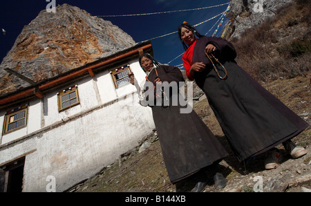 Zwei chinesische Frauen stand außerhalb eines Mönchs Heimat hoch in die Berge in Tibet Stockfoto