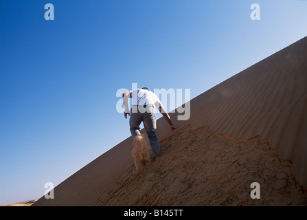 Klettern einer Sanddüne in der Sahara Wüste, Mauretanien Stockfoto