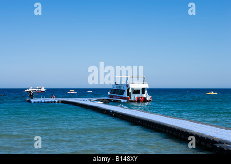 Glasboden-Boot festgemacht an einem schwimmenden Steg Strand von Naama Bay, Sharm el-Sheikh, Küste des Roten Meeres, South Sinai, Ägypten Stockfoto