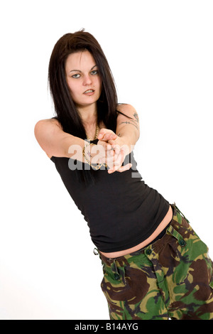 Eine Frau im Kampf gegen Hosen und eine schwarze Weste Top vorgibt, eine Waffe zu halten. Stockfoto