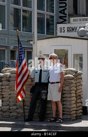 Berlin. Checkpoint Charlie heute. Ehemaligen Alliierten Grenze Kontrollpunkt. Schauspieler als amerikanischer Soldat posiert mit Touristen. Stockfoto