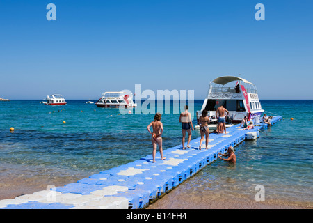 Glasboden-Boot festgemacht an einem schwimmenden Steg Strand von Naama Bay, Sharm el-Sheikh, Küste des Roten Meeres, South Sinai, Ägypten Stockfoto