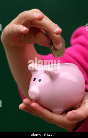 Sparschwein und Childs Hand mit Geld Stockfoto
