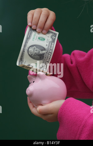 Platzieren zwei Dollar american Banknote in ein Sparschwein Kind Stockfoto