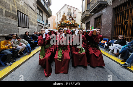 Büßer tragen religiöse Statuen während Osterprozession in Crevillente Murcia Spanien Stockfoto