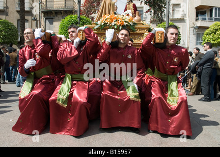 Büßer tragen religiöse Statuen während Osterprozession in Crevillente Murcia Spanien Stockfoto