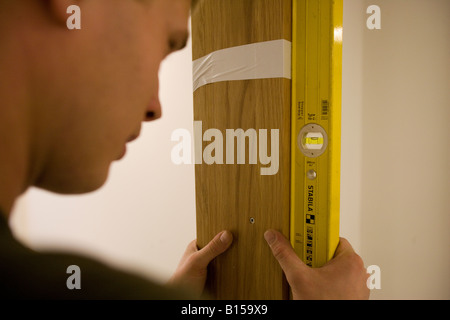 Ein Arbeiter prüft eine Armatur mit einer Wasserwaage. Stockfoto