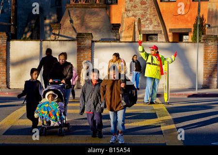 Spanisch Schule Kreuzung Wache steuert Straßenverkehr als Süd-Kalifornien Grundschüler und Eltern kommen in AM Stockfoto