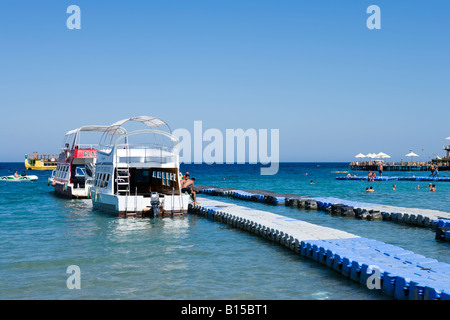 Glasbodenboote festgemacht an einem schwimmenden Steg Strand von Naama Bay, Sharm el-Sheikh, Küste des Roten Meeres, South Sinai, Ägypten Stockfoto