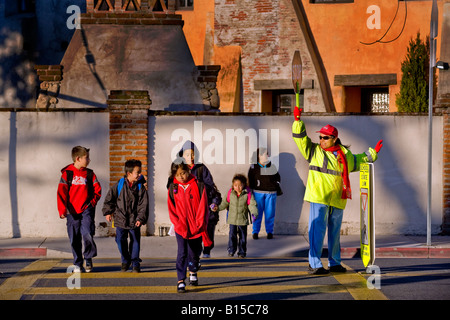 Spanisch Schule Kreuzung Wache steuert Straßenverkehr als Süd-Kalifornien Grundschüler und Eltern kommen in AM Stockfoto