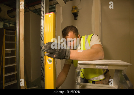 Ein Arbeiter hält eine Wasserwaage die Ausrichtung eines Fittings überprüfen. Stockfoto