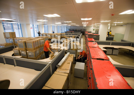 Arbeiter packen neue Aktenschränke während Ausstattung ein neu errichtetes Bürogebäude. Stockfoto