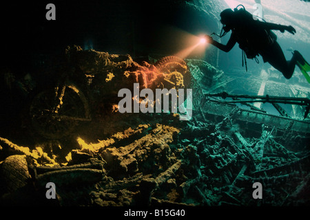 Eine Taucher erstrahlt ihre Fackel 1941 Motorrad im Laderaum des WW2 SS Thistlegorm Schiffbruch in Straße von Gubal, Rotes Meer. Stockfoto