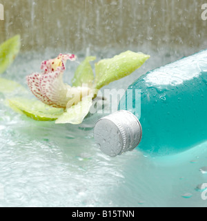 Lotion in Flasche und Blüten der Orchidee, Nahaufnahme Stockfoto