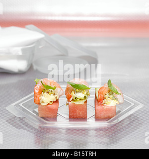 Melonenscheiben mit Garnelen auf Kunststoffplatte Stockfoto