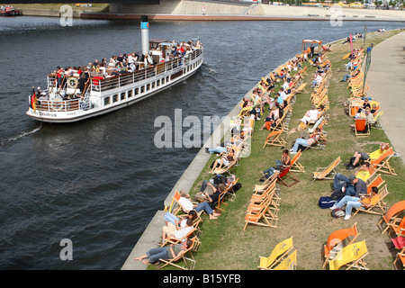 Berlin Deutschland Genuss-Kreuzfahrt-Schiff auf der Spree geht Sonnenanbeter am Ufer Ufer Stockfoto