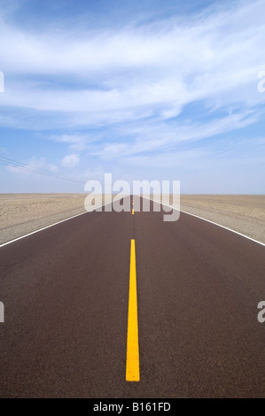 Teil der Pan-American Highway in der Wüste zentriert und führen aus der Distanz mit gelben Trennlinien und blauer Himmel. Stockfoto